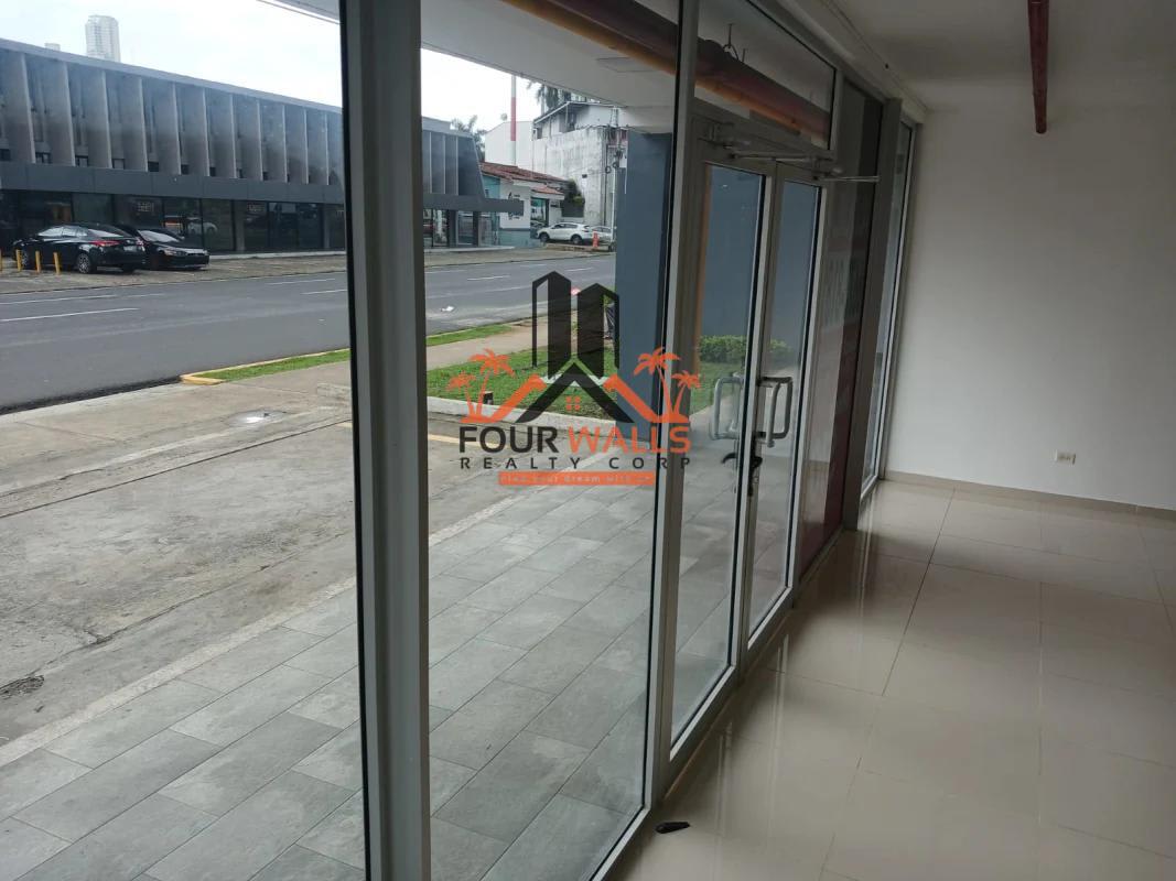 Glass storefront space with white walls, tile flooring, empty interior in Via España business plaza Panama