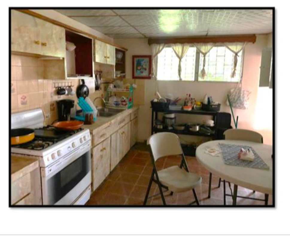 Kitchen with dining nook, gas stove, large windows, beige cabinets, tiled floor in Panama house