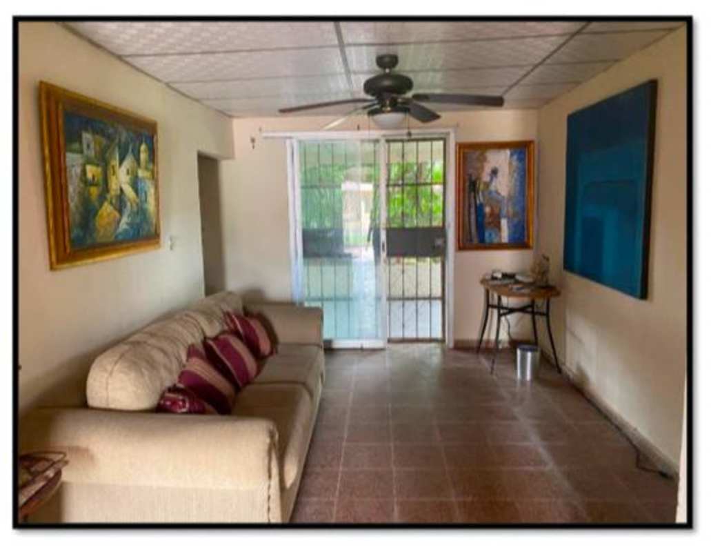 Living room with sofa, paintings, ceiling fan, sliding glass door in Juan Díaz house Panama