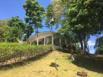 White tropical bungalow with wrap around porch hilltop site Isla Gobernadora Panama