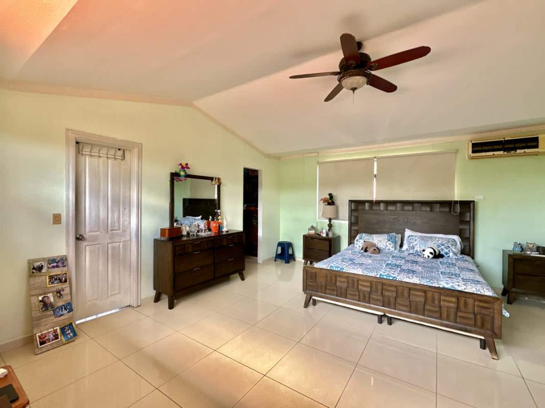 Aerial of Mediterranean villa with lush garden by lake Las Cumbres in Panama City