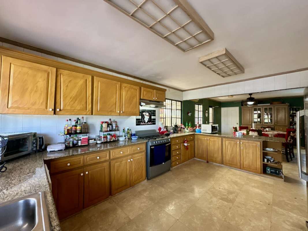 Spacious bedroom with wood floors, modern furniture, ceiling fan in luxury villa Las Cumbres Panama