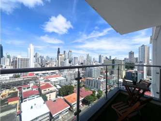 Private balcony overlooking skyline with outdoor furniture PH Cranc Tower