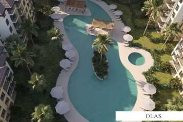 Large lagoon pool with island, sun deck and clubhouse at Olas del Mar Playa Caracol