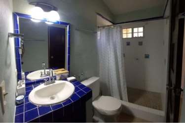 Lit swimming pool and jacuzzi amidst lush gardens at night in Costa Esmeralda estate Panama