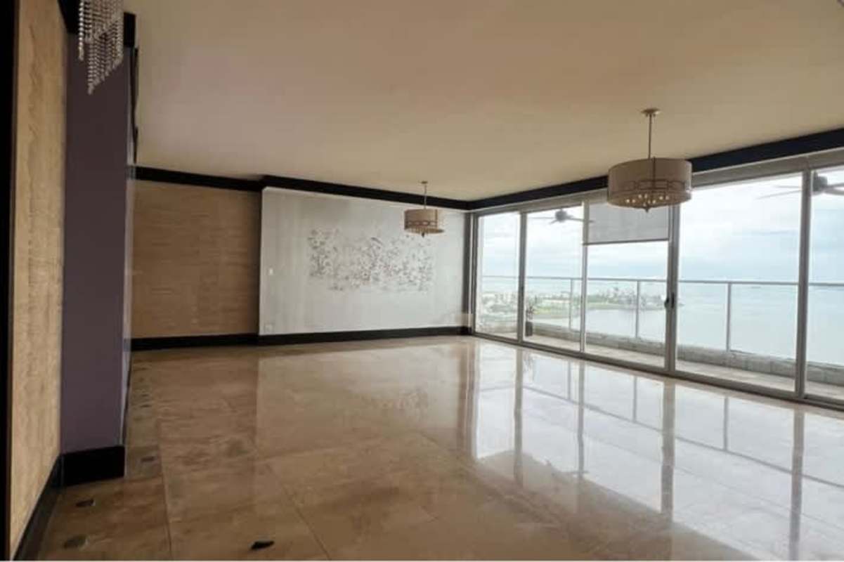 Living room with marble floors and floor to ceiling windows overlooking ocean in PH Q Tower Panama City