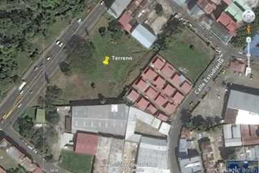 Urban vacant lot site with mature trees sidewalk and street lighting in Ancón Panama City