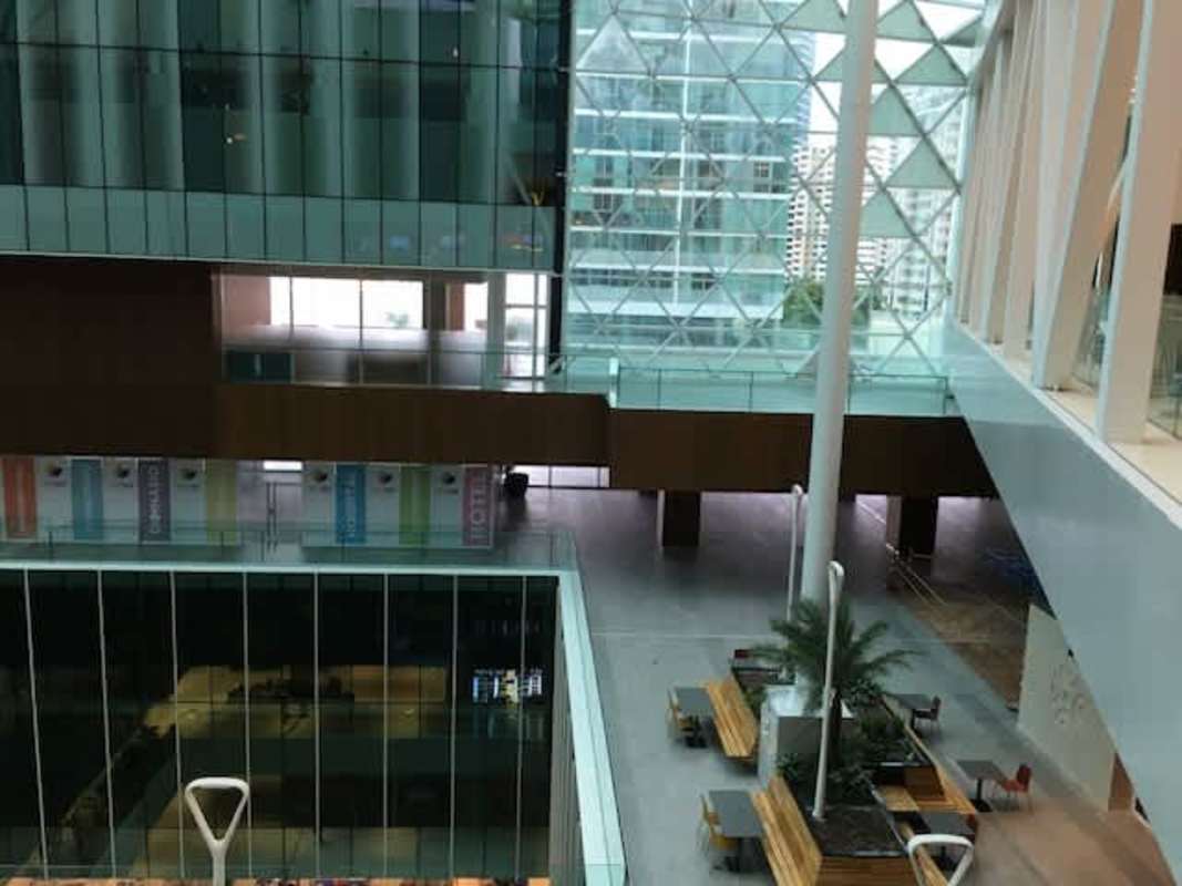 Interior glass atrium with digital signage and indoor greenery vertical garden in Pacific Center Panama