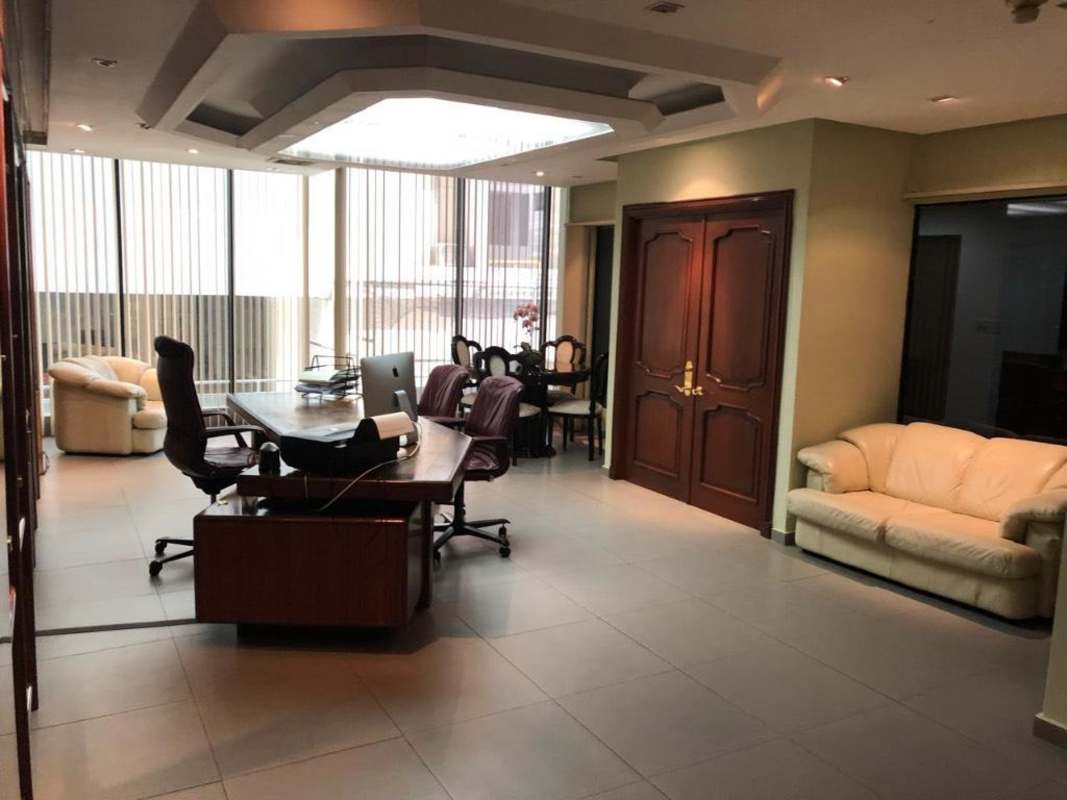 Corner private office with large windows and wood decor PH Omega Panama City