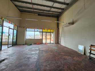 Spacious commercial interior with industrial exposed ceiling and glass entrance in Plaza Paseo Arraiján Panama