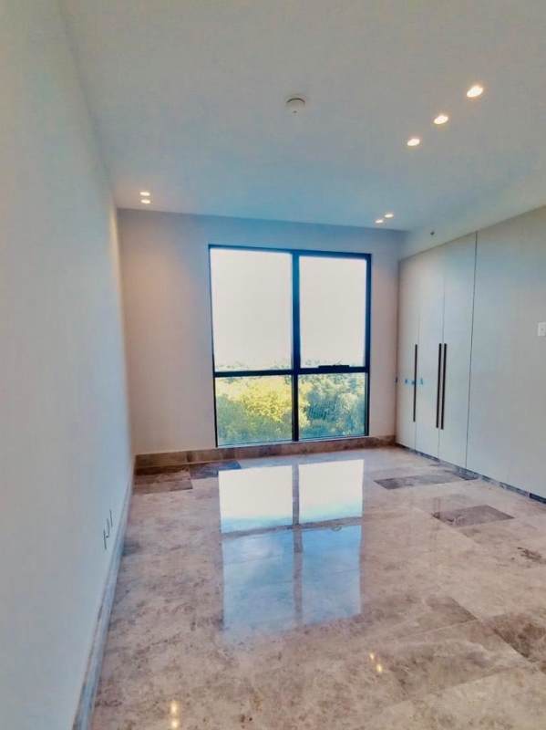 Modern bedroom with marble floors, built-in wardrobe, scenic window in Empire Residences Santa María Panama