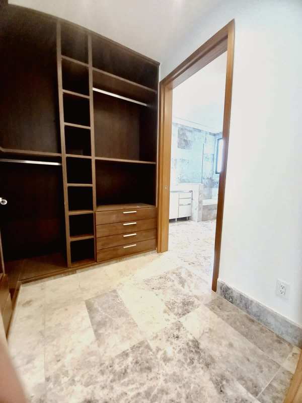 Modern closet with custom wooden shelving and drawers in Empire Residences Panama