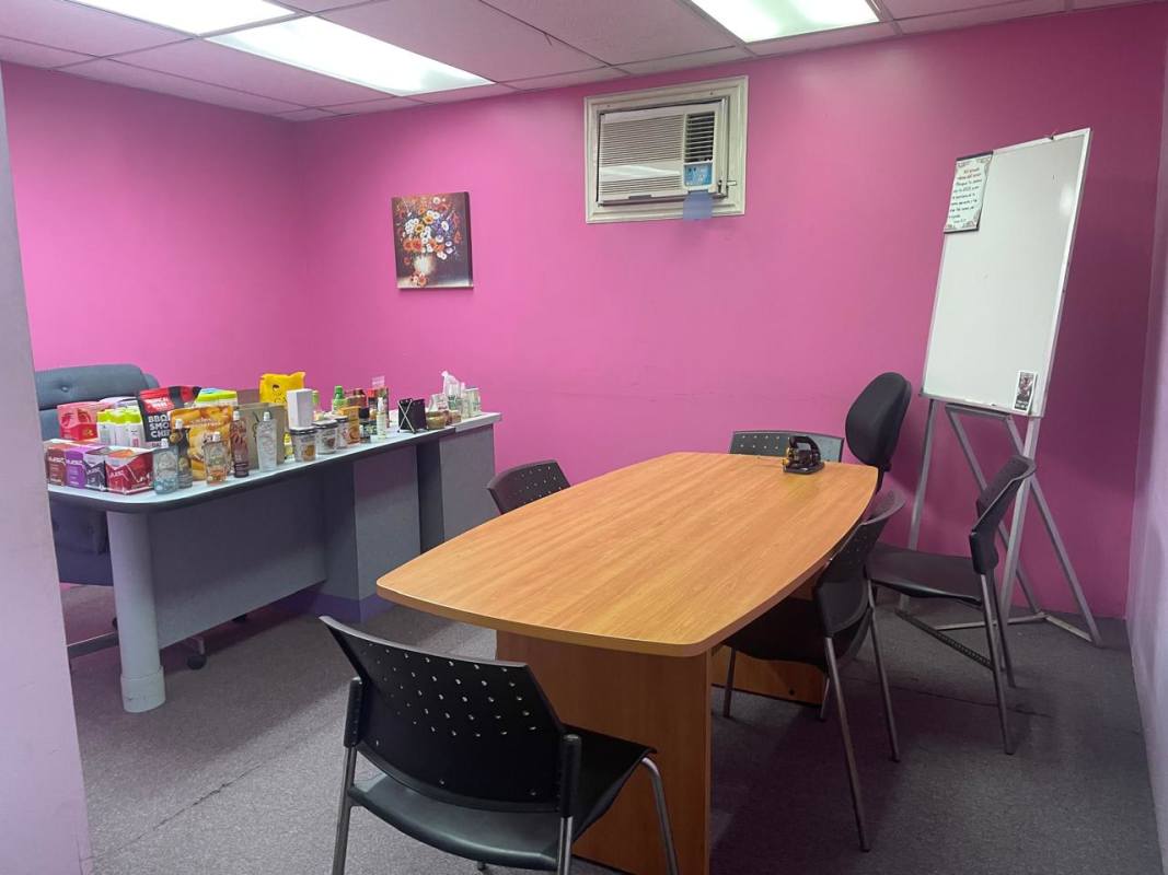 Office meeting space with pink walls, whiteboard, tables, chairs in commercial property Panama