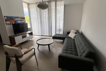Living room with large windows, modern furniture and balcony in Panama Pacifico apartment