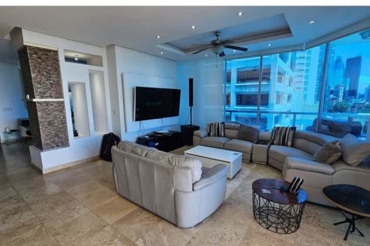 Spacious living room with floor-to-ceiling windows showcasing ocean and city views in PH Sky Residences Panama City