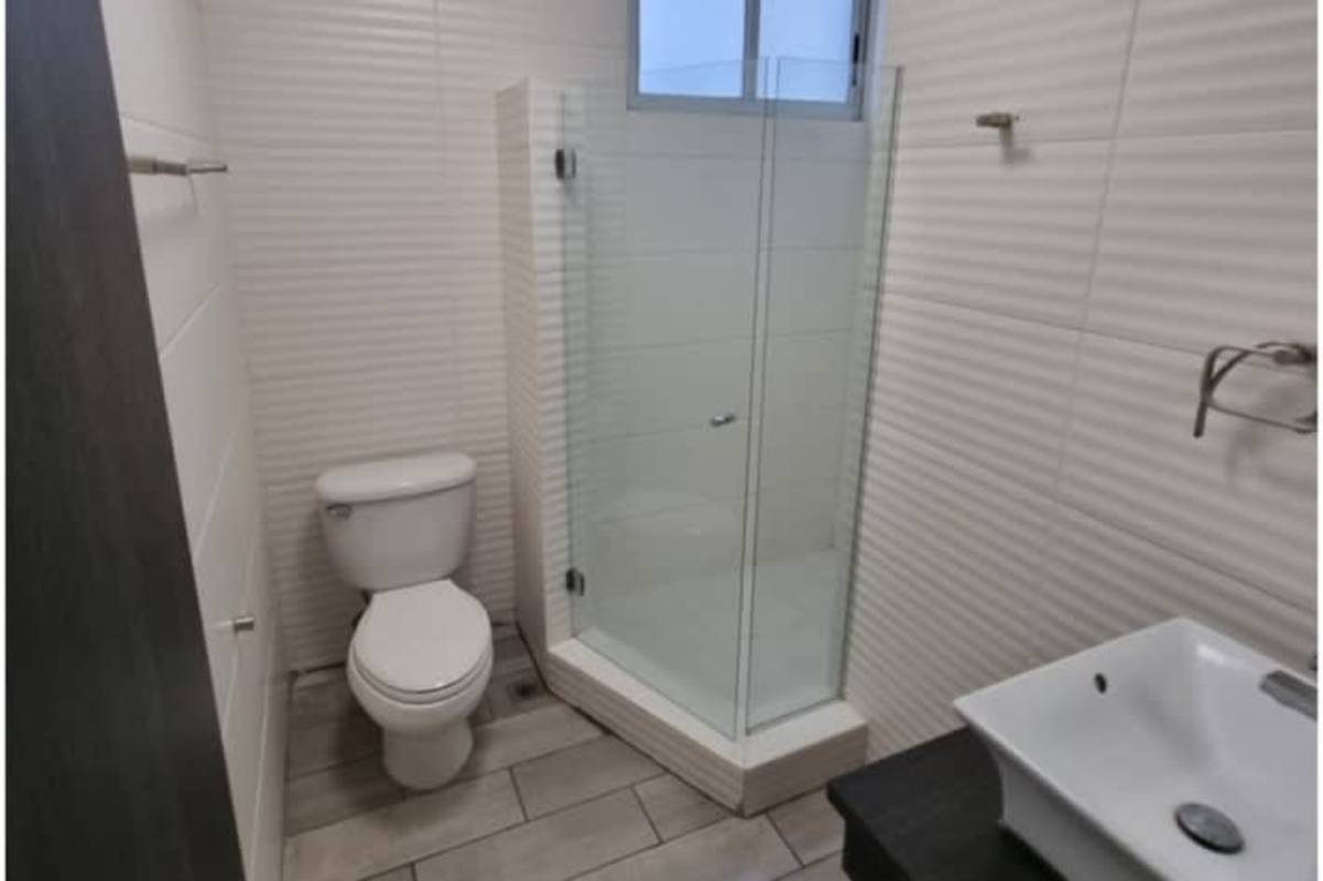 Master bathroom featuring glass shower enclosure, marble tiles, dual vanity sinks in Pacific Point Tower Panama