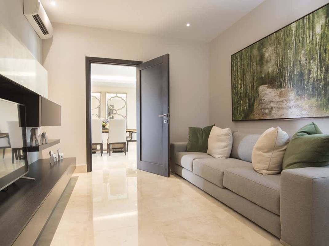 Living area with sofa, wall-mounted TV, and marble flooring at The Colonial Panama