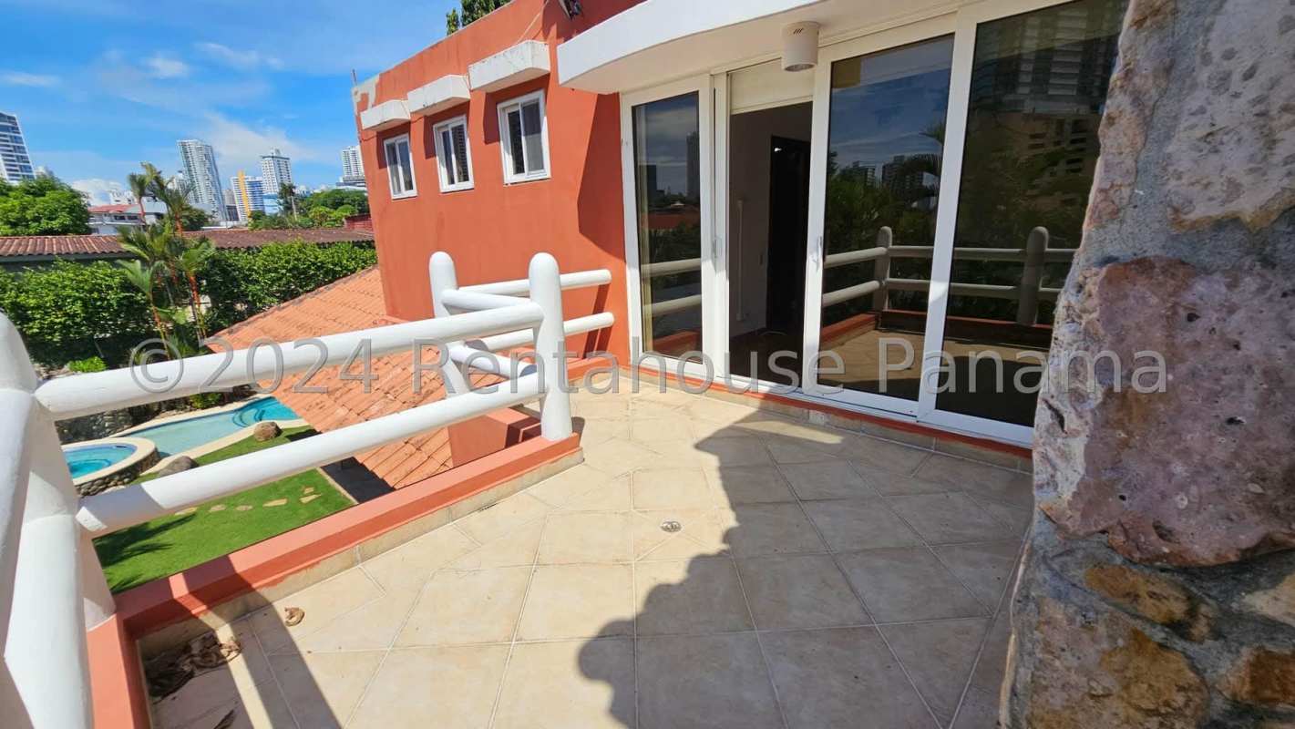 Mediterranean-inspired covered terrace with pool and garden view in Altos del Golf house Panama City