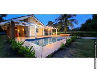 Contemporary beach house with pool, pergola, and lush gardens in Punta Chame Panama at dusk