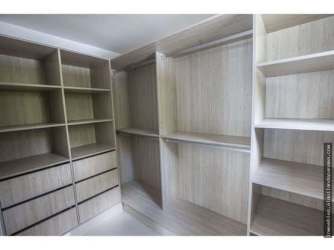 Spacious walk-in closet with built-in shelves and drawers in Costa Verde master bedroom Panama