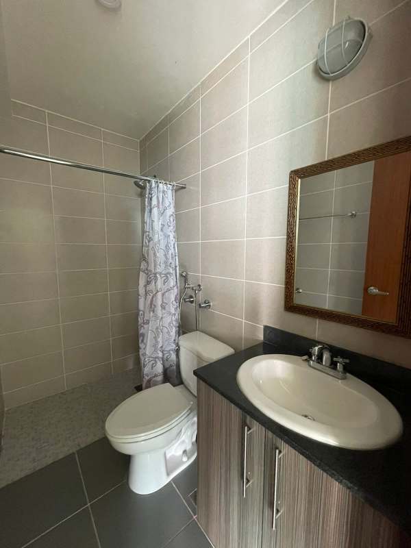 Modern bathroom with walk-in shower, tiled walls and single vanity in Residencias del Sol Carrasquilla Panama