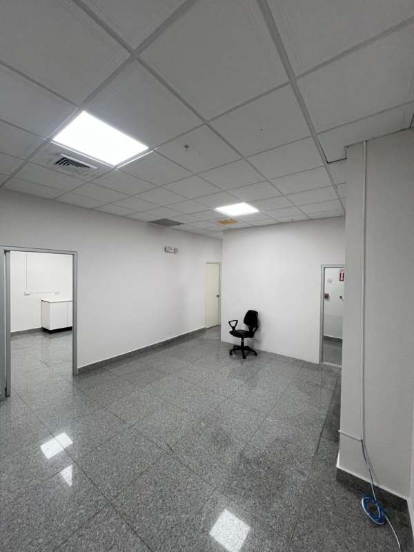 Minimalist lit office room with two black chairs, large windows city view Plaza Fidanque Panama