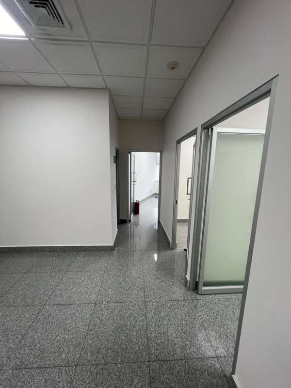 Modern commercial hallway with glass office partitions and gray tile floor in Plaza Fidanque Panama
