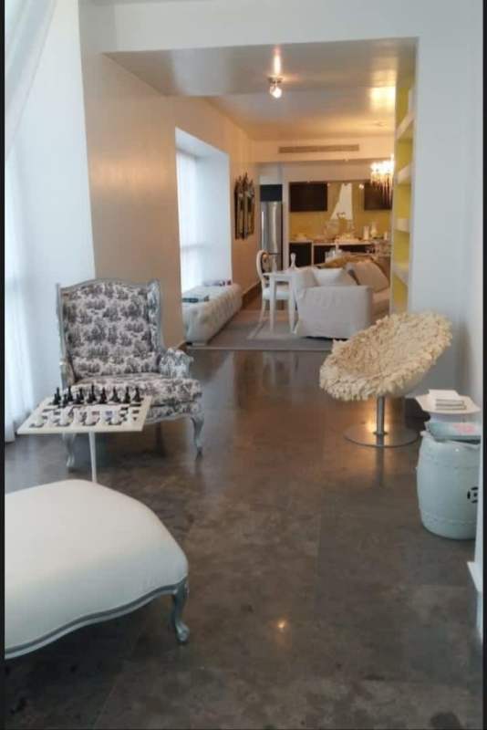 Modern open dining and living room with balcony and ocean views at PH Yoo Panama