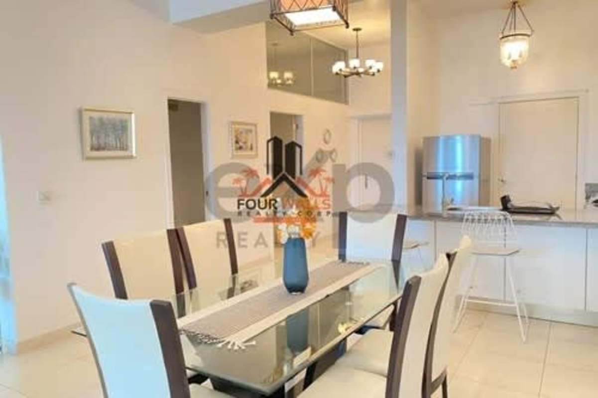 Modern open-plan dining with glass table and granite kitchen at Waters on the Bay Panama City