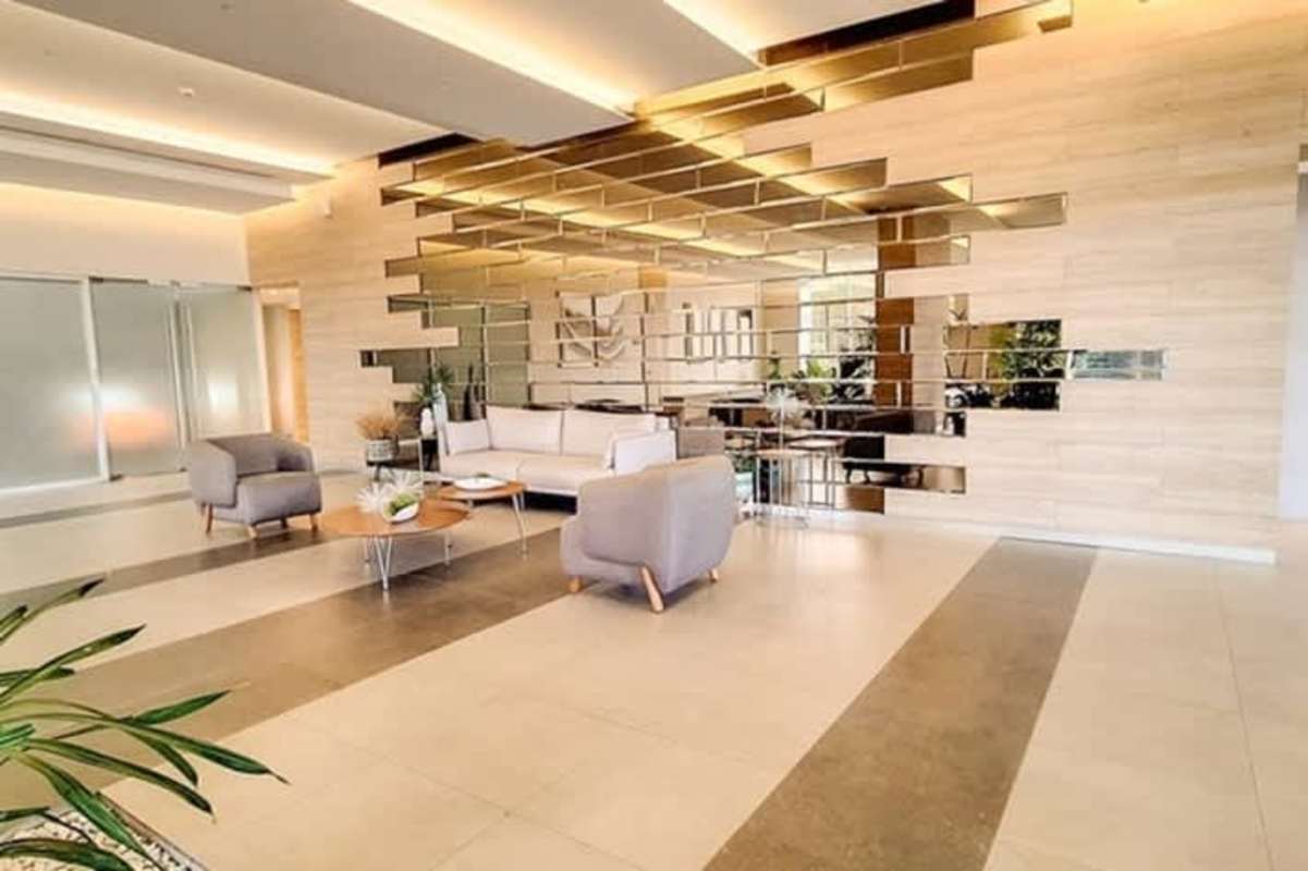 Spacious lobby with stylish mirrored wall, contemporary seating, and tile floors in PH Green View Betania