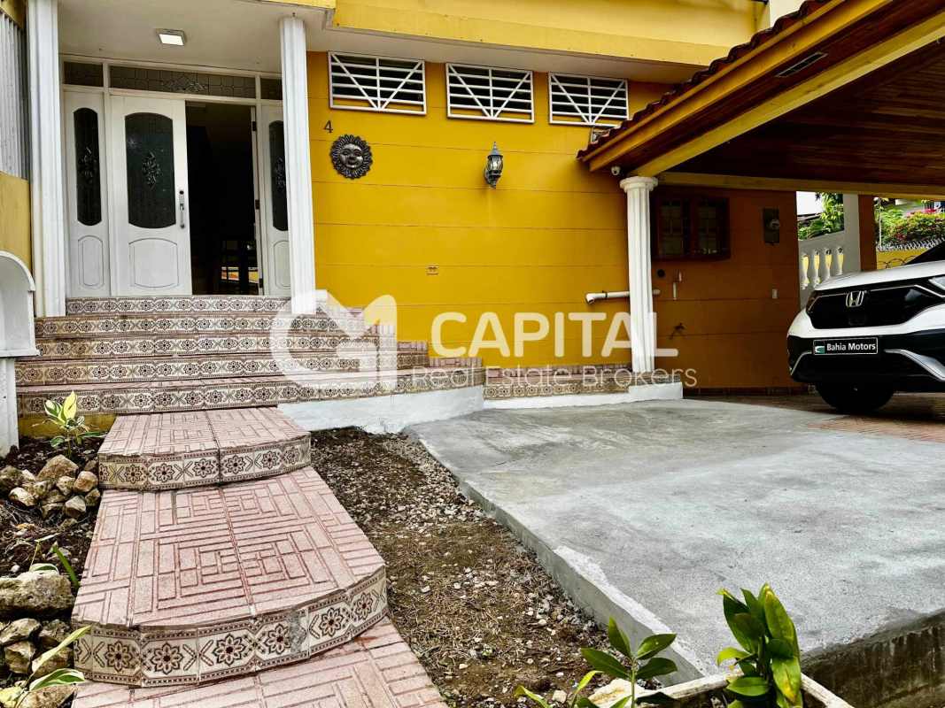 Outdoor covered terrace with stone wall, pergola, and garden in Betania Panama commercial residence