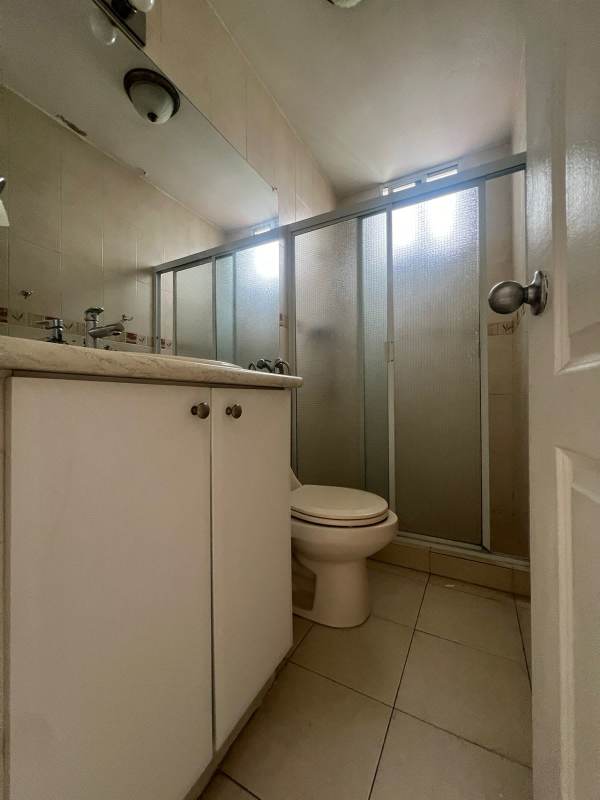 Modern bathroom with beige tiles and frosted glass shower at PH Plaza 77 El Cangrejo Panama City