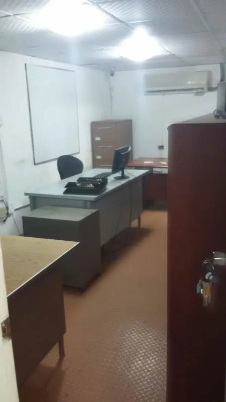 Functional small office setup with AC, desk, and whiteboard inside industrial warehouse in Pueblo Nuevo Panama