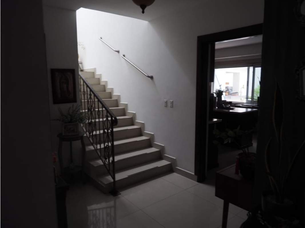 Bright living room with large windows, leather sofa, garden view in Altos del Golf Panama