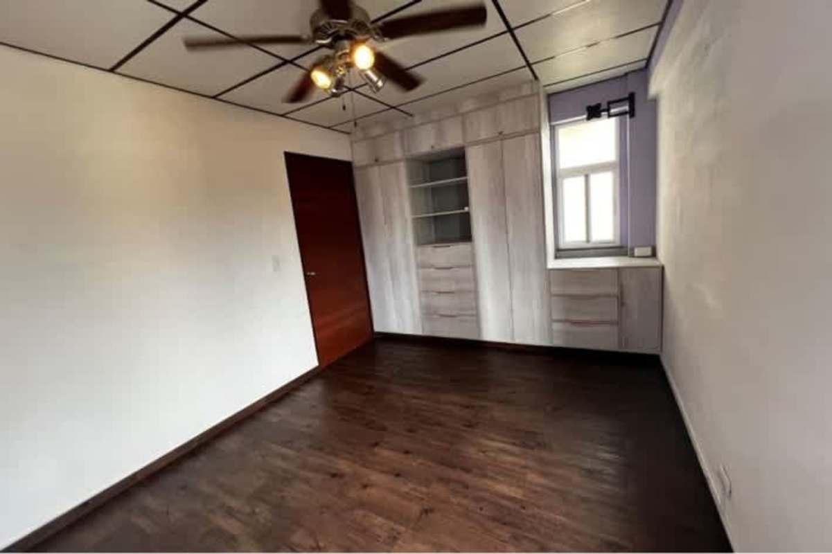 Bedroom featuring built-in closet, wood floors, and window in PH Carmen Edith Panama