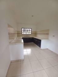 Minimalist L-shaped kitchen tiled countertops window in Residencial Aqualina Panama