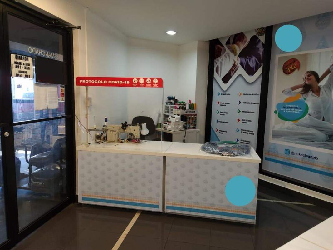 Workspace with sewing machines, counters and promotional signage laundry and tailoring shop in Panama