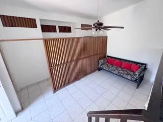 Spacious kitchen with white cabinets, black countertops, large windows and tile flooring in Punta Chame villa