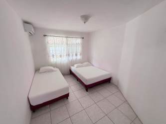 Living room with ceiling fans, TV, tile floors and patio view at Punta Chame beachfront house