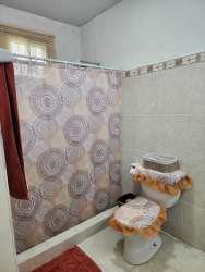 Bathroom with tiled walls, walk-in shower, decorative border in rural house Panama
