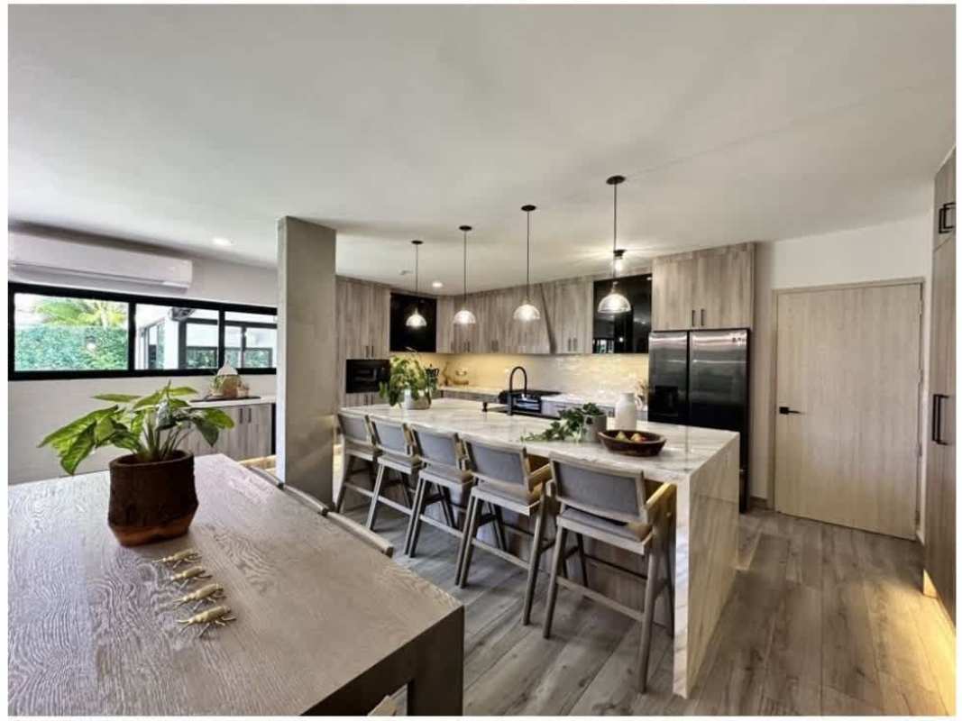 Modern dining room with pendant lights open to marble island kitchen in PH Quintas de Versalles Panama