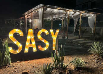 Illuminated lounge area with string lights beside rustic cabins for sale in Santa Catalina Panama