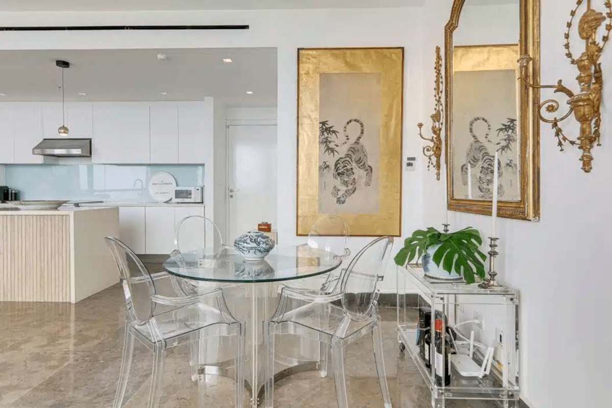 Dining area with acrylic chairs and gold-accented decor in renovated condo Yoo Panama