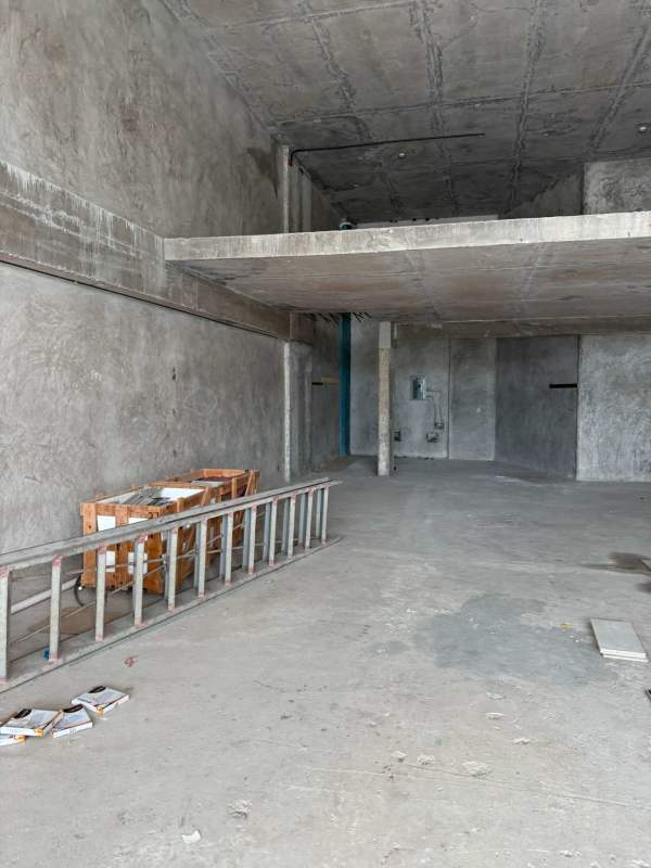 Unfinished commercial unit interior with raw concrete walls mezzanine and open floor plan in City Mall Panama