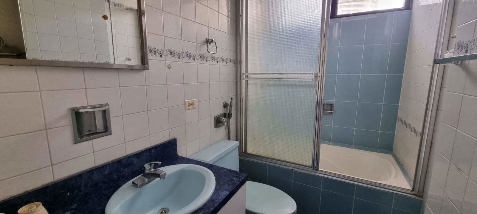 Bathroom with blue tile design, bathtub with shower and mirror cabinet in PH Park Loft Panama