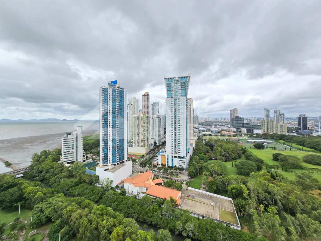 Bright master bedroom with large window, marble floors, city and ocean views at PH Aria