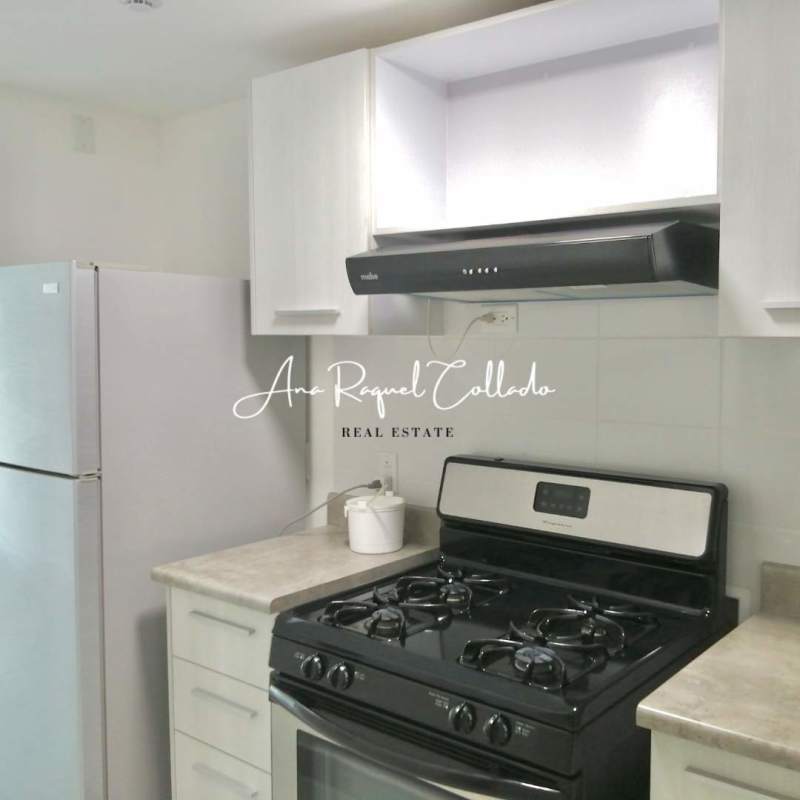 Kitchen with gas stove, refrigerator, and white cabinets PH ILO apartment Panama