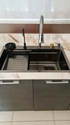 Modern kitchen sink and fixtures with bright window in Panama Pacifico condo