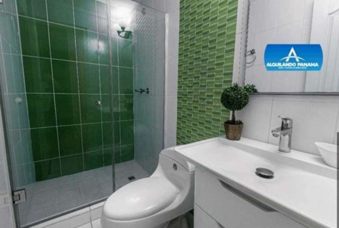 Bathroom with green tile glass shower white fixtures Monte Oscuro house Panama