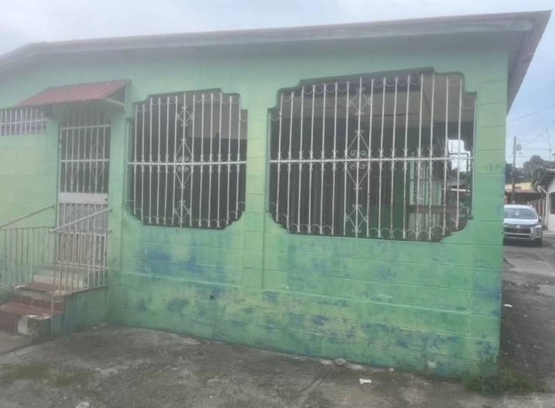 Enclosed tiled porch with metal bars and green walls in corner house Torrijos Carter Panama City